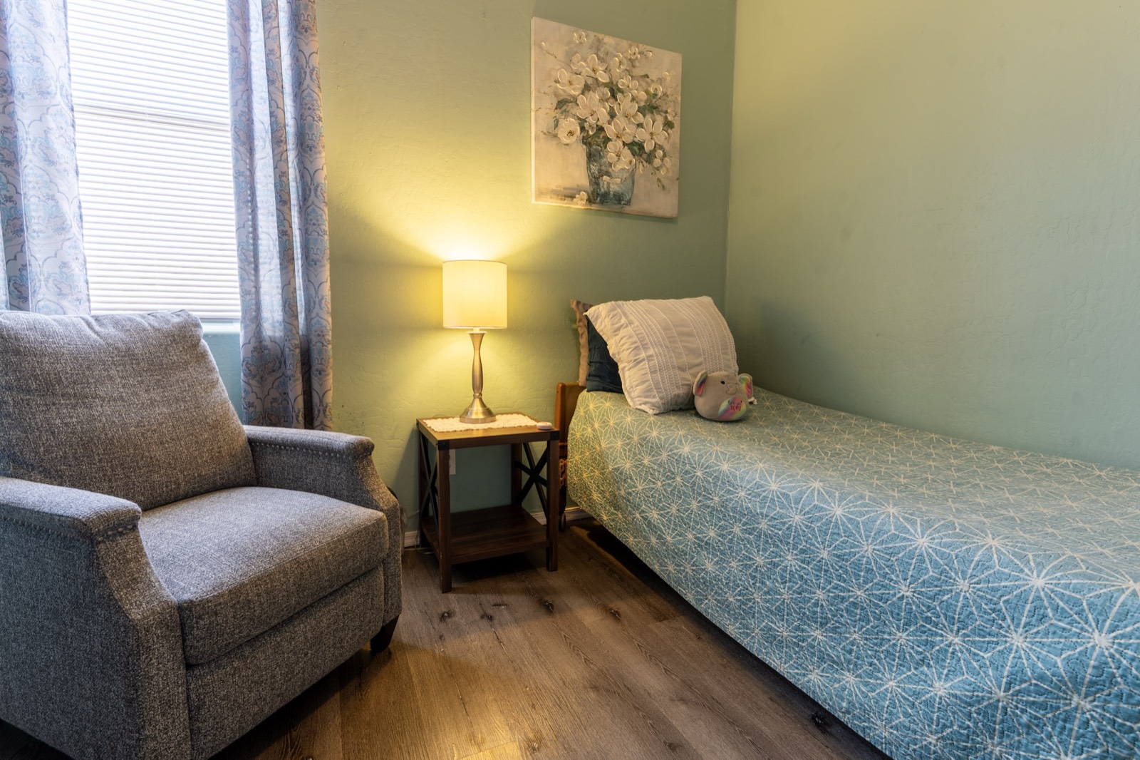 A cozy, comfortable private bedroom with a sitting chair at Grace Hill Ranch